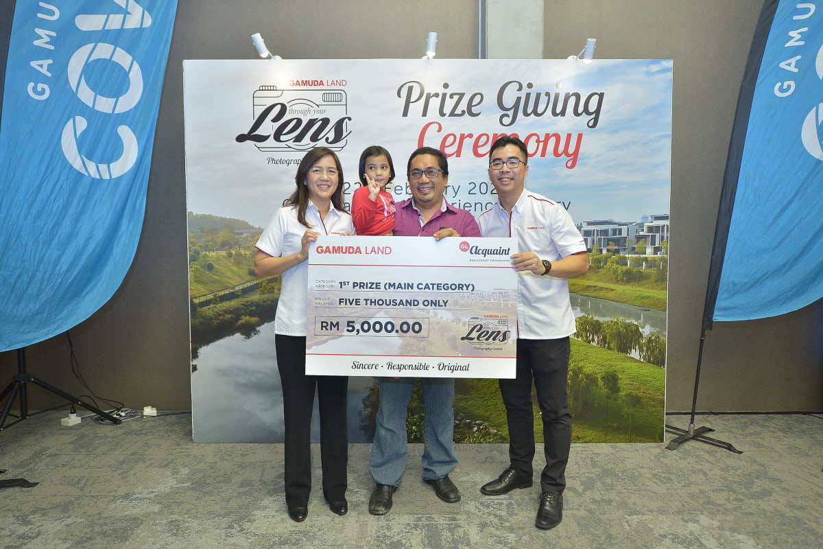 Proud moment: The first prize winner of Gamuda Land's 'Through Your Lens' January photography contest, Abdul Hafiz Ab Hamid (centre), is flanked by Aw (right) and marketing and sales executive director Lillian Lung at the Gamuda Cove township in Dengkil, Selangor. 