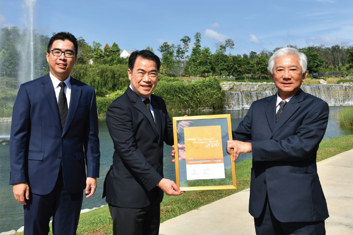 Ngan receiving the award from The Edge Media Group publisher and group CEO Datuk Ho Kay Tat. With them is Gamuda Land chief operating officer Aw Sei Cheh.